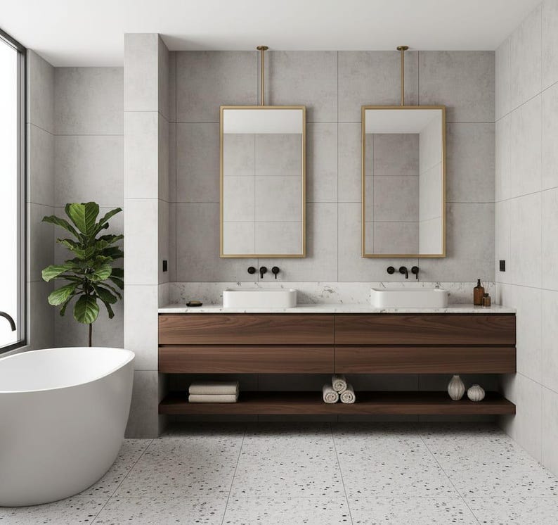 May include: A bathroom featuring a floating dark wood vanity with two white rectangular sinks, matte black faucets, and two gold-framed rectangular mirrors suspended from the ceiling. A white freestanding bathtub sits to the left.