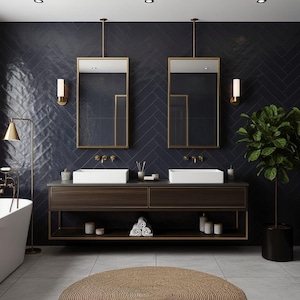 May include: A bathroom vanity with a dark wood finish, two white rectangular sinks, and gold faucets. Above are two rectangular mirrors with gold frames, wall-mounted lights, and dark blue herringbone tiles. A potted plant sits to the right.