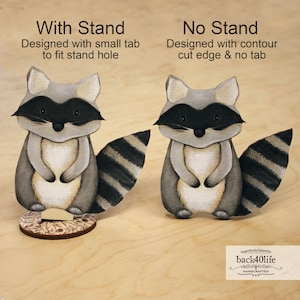 May include: Two papercraft raccoon figurines, one with a stand and one without. The raccoon with the stand has a small tab to fit into the stand hole. The raccoon without the stand has a contour cut edge. Both raccoons have black and white striped tails and are painted in shades of grey, brown, and white.
