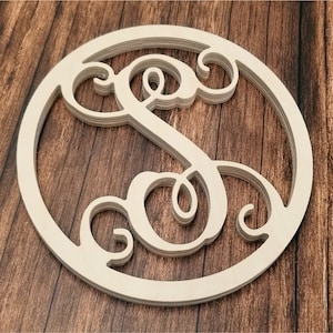 May include: A wooden round sign with a layered, cursive letter "S" cut out in the center. The sign is unfinished and has a natural wood color.