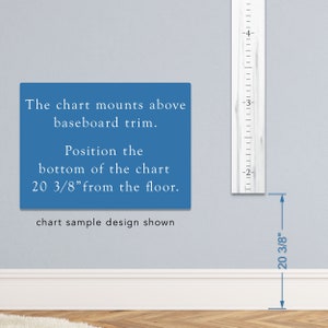 May include: A white wooden growth chart with black markings, showing measurements in inches. The chart is mounted on a wall above a white baseboard. Text on the wall reads: "The chart mounts above baseboard trim. Position the bottom of the chart 20 3/8" from the floor. chart sample design shown"