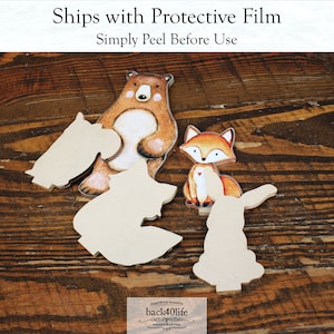 May include: Four unfinished wooden animal shapes, a bear, a fox, a rabbit, and a horse, are arranged on a wooden surface. The bear, fox, and horse shapes are painted with brown, orange, and white paint. The text "Ships with Protective Film Simply Peel Before Use" is visible at the top of the image.