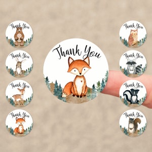 May include: Set of 9 round thank you stickers featuring woodland animals. The stickers have a white background with a green forest scene and the text "Thank You". Each sticker features a different animal, including a fox, bear, owl, rabbit, deer, raccoon, skunk, and squirrel.