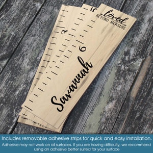 May include: A wooden growth chart with a woodgrain pattern and black markings. The chart is labeled with the name "Savannah" and the phrase "Loved Beyond Measure".