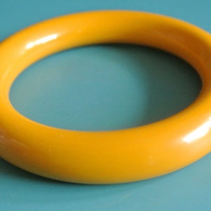 Op de afbeelding: Een felgele plastic armband.
