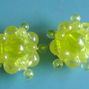 Paire de plus grandes boucles d’oreilles vintage des années 1950, typique de la perle en plastique vert limedé, avec des clips en laiton, toujours sur carte