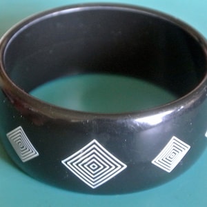 Wide vintage 1980s moulded black lucite plastic bangle bracelet with thin white abstract decor