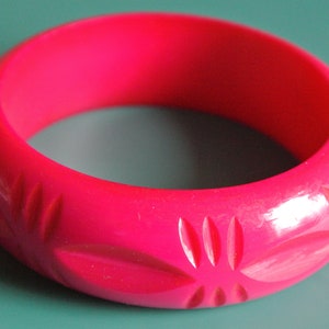 Vintage 1990s deeply carved heavvy strong cerise pink resin plastic bangle bracelet with abstract decor
