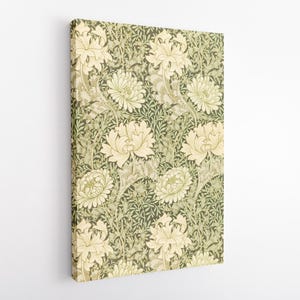 May include: A rectangular canvas print displaying a repeating floral pattern. The design features large, cream-coloured flowers with detailed elements, set against a backdrop of dark green foliage. The artwork is mounted on a wooden frame.