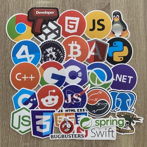 May include: A collection of colorful round stickers featuring various programming languages, frameworks, and technologies. The stickers include logos for JavaScript, Python, C++, C#, HTML, CSS, Java, Swift, Spring, .NET, and more. The stickers are arranged in a grid pattern on a wooden surface.