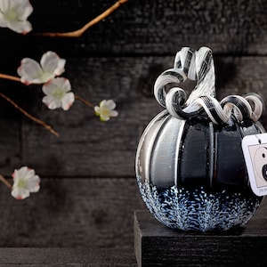 May include: Black and white glass pumpkin with a swirl design on the stem. The pumpkin has a white yin yang symbol on the side with the text "Yin Yang Pumpkin".