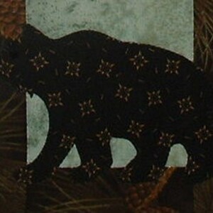 Könnte beinhalten: Eine schwarze Bärensilhouette mit einem braunen und goldenen Muster auf einem blauen und grünen Hintergrund mit Kiefernnadeln und Tannenzapfen.