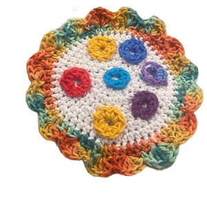 May include: A white crocheted coaster with a colorful rainbow border and six colorful crocheted circles in the center.