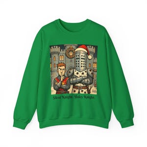 Op de afbeelding: Groene kersttrui met een cartoon afbeelding van twee ridders voor een kasteel. De ridder links houdt zijn vinger op zijn lippen en de ridder rechts draagt een kerstmanmuts. De tekst "Silent Knight, Holey Knight." is onder de afbeelding gedrukt.