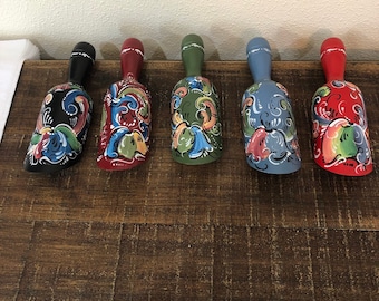 May include: Five wooden scoops painted in traditional Swedish folk art style. The scoops are in various colors, including black, red, green, blue, and yellow. Each scoop features a unique floral design.