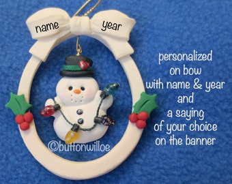 Personalized Snowman with Christmas lights inside oval ornament accented with red and green holly
