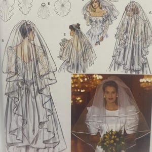 May include: A Burda sewing pattern packet for wedding veils. The packet features illustrations of various veil styles, including cathedral, blusher, and fingertip veils. The packet is sealed in a clear plastic bag.