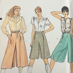 May include: A vintage Vogue sewing pattern for women's culottes. The pattern is for size 12 and features three different styles of culottes. The pattern is printed on white paper with black and red text. The pattern is titled "Very Easy Vogue" and has a price of £4.50.