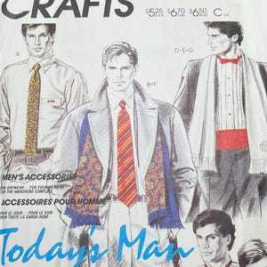 Op de afbeelding: Een vintage McCall's Crafts patroon envelop met illustraties van herenaccessoires. De omslag bevat de tekst "Today's Man" in blauw script, met afbeeldingen van mannen die stropdassen, sjaals en vlinderdassen dragen. De envelop is wit met zwarte tekst.