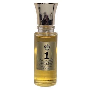 Op de afbeelding: Een kleine parfumfles met een zilveren dop en een heldere glazen body. Het etiket luidt "1 Galimard Parfumeur en 1747 GRASSE". De vloeistof binnenin is amberkleurig.