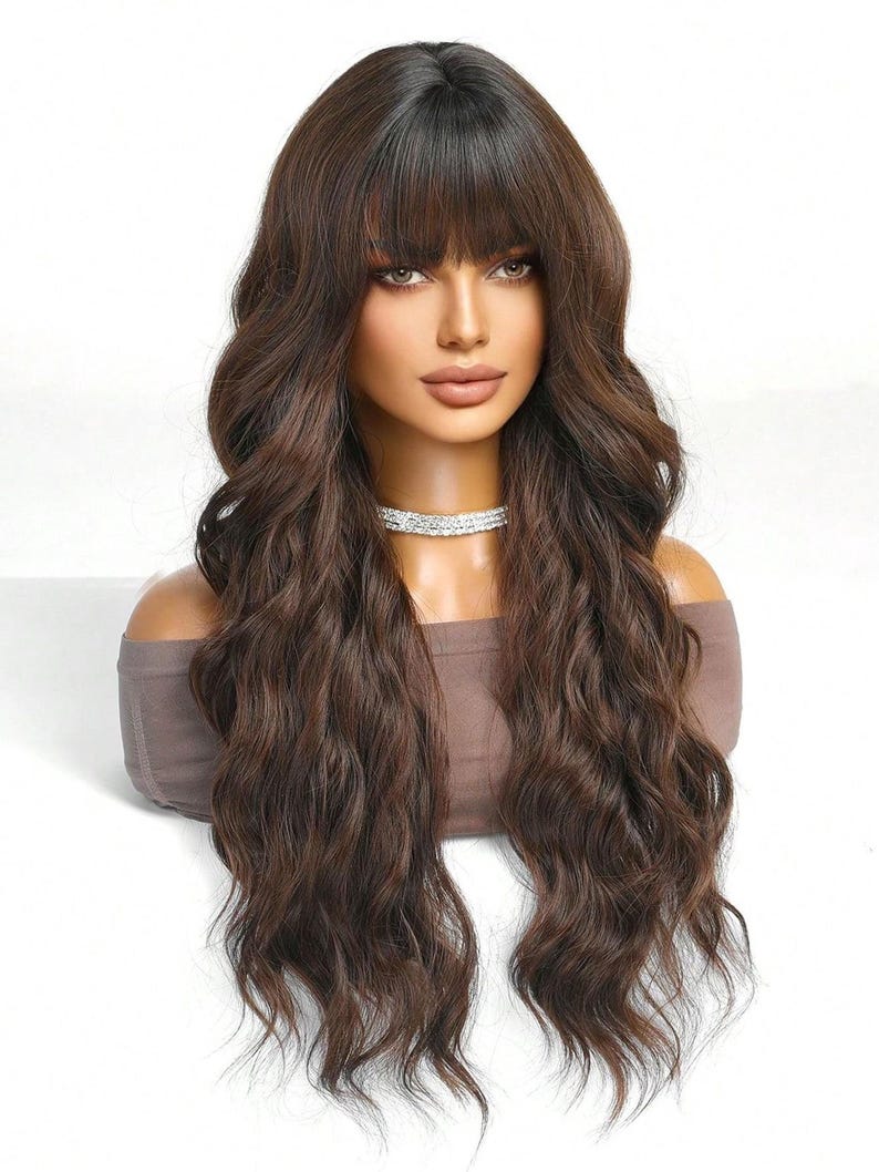 A mannequin head with long, wavy brown hair styled in a side part and bangs. The mannequin is wearing a necklace.