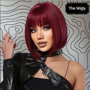 A woman with long, dark red hair wearing a black leather jacket and posing against a black and white abstract background.