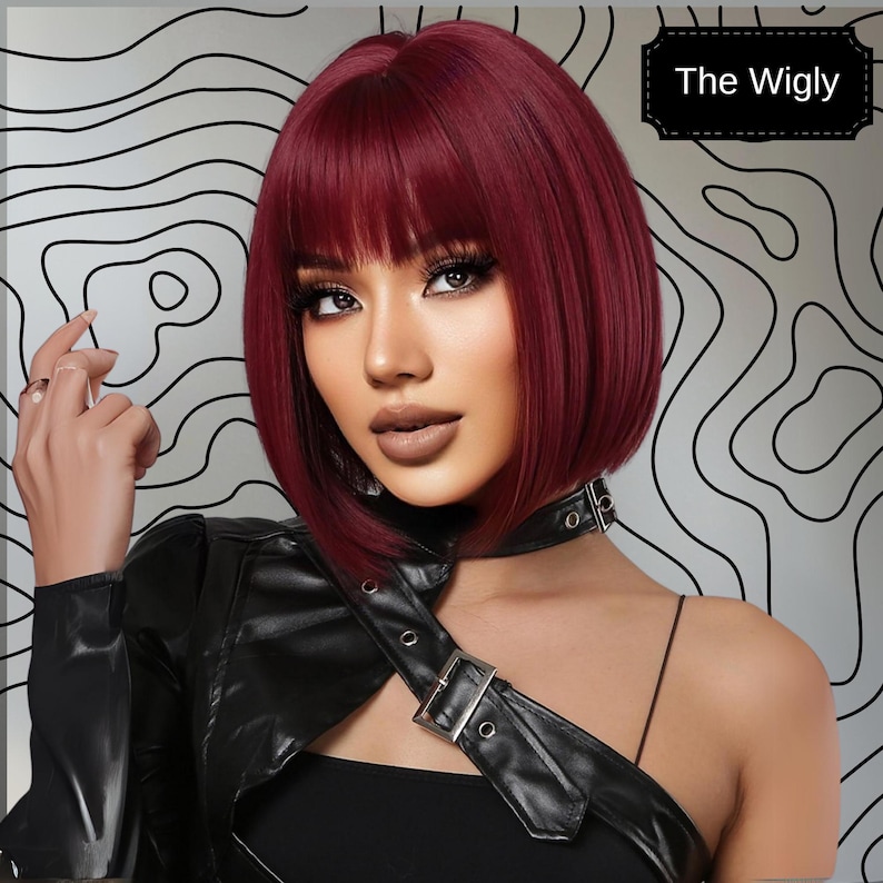 A woman with long, dark red hair wearing a black leather jacket and posing against a black and white abstract background.