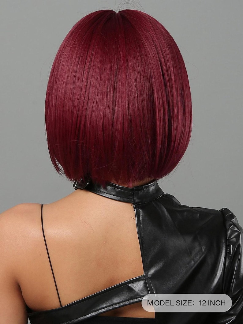 the back view of a person with short, dark red hair. The person is wearing a black leather jacket.