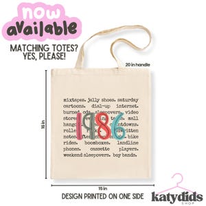 Puede incluir: Un bolso de tela beige con el texto 1986 en n&uacute;meros grandes, coloridos y estilizados, rodeado por una lista de t&eacute;rminos nost&aacute;lgicos. El bolso mide 40,64 cm de alto y 38,1 cm de ancho, con un asa de 50,8 cm. El dise&ntilde;o est&aacute; impreso en un lado.