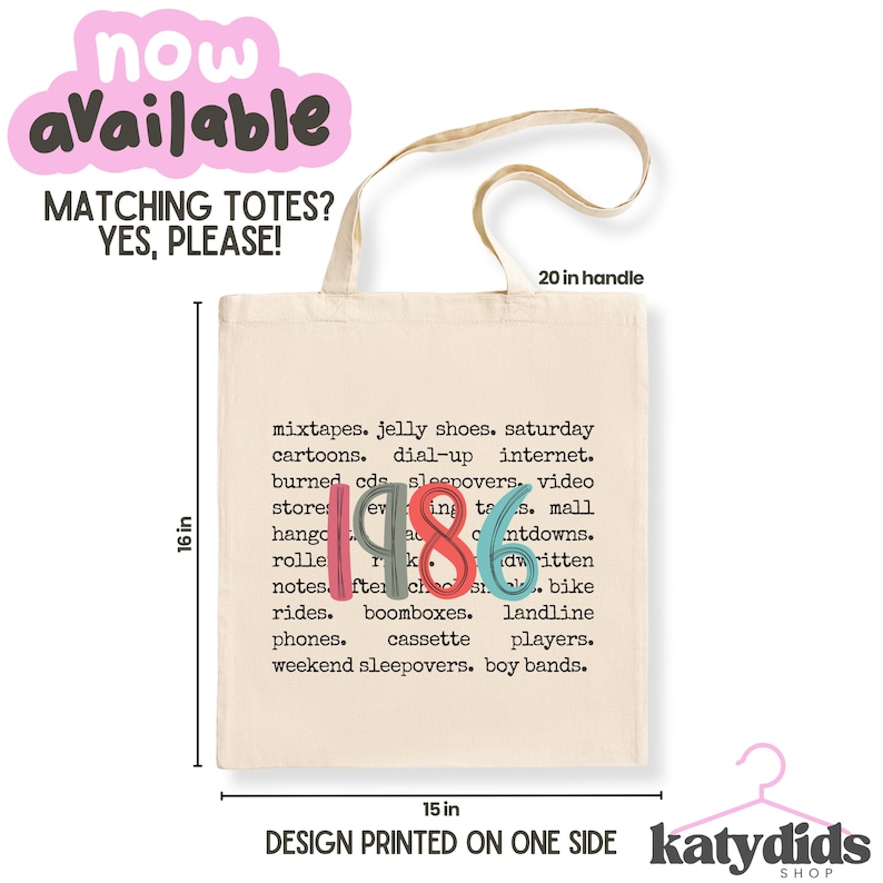 Puede incluir: Un bolso de tela beige con el texto 1986 en n&uacute;meros grandes, coloridos y estilizados, rodeado por una lista de t&eacute;rminos nost&aacute;lgicos. El bolso mide 40,64 cm de alto y 38,1 cm de ancho, con un asa de 50,8 cm. El dise&ntilde;o est&aacute; impreso en un lado.