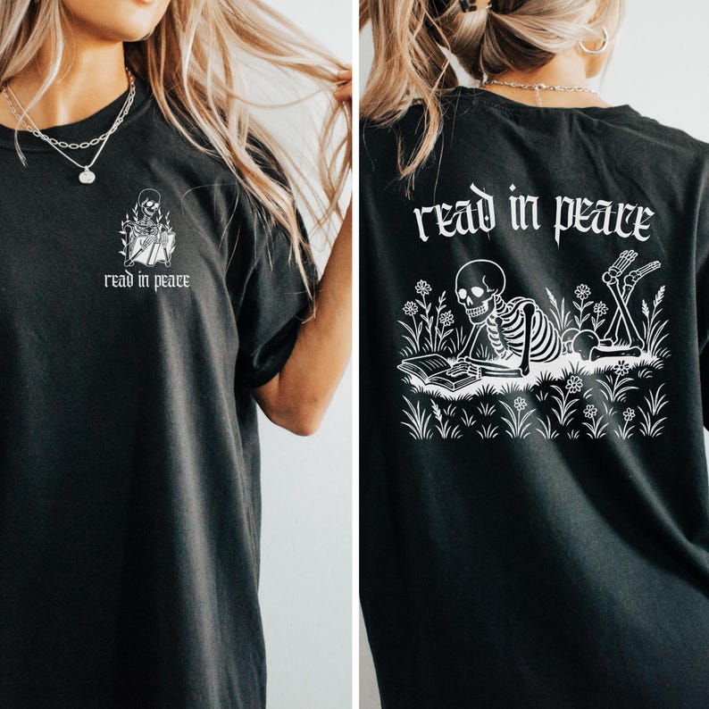 Puede incluir: Camiseta negra con un dise&ntilde;o blanco de un esqueleto leyendo un libro, con el texto "read in peace". La parte trasera de la camiseta presenta una versi&oacute;n m&aacute;s grande del dise&ntilde;o y el texto. Un dise&ntilde;o &uacute;nico y llamativo.