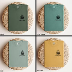Puede incluir: Cuatro camisetas en colores musgo, verde claro, bah&iacute;a y mostaza se muestran sobre esteras circulares tejidas. Cada camiseta tiene un peque&ntilde;o gr&aacute;fico y el texto "read in peace" impreso en la parte delantera.