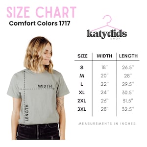 K&ouml;nnte beinhalten: Eine Gr&ouml;&szlig;entabelle f&uuml;r Comfort Colors 1717 T-Shirts von Katydids Shop. Die Tabelle zeigt Breiten- und L&auml;ngenma&szlig;e in Zoll f&uuml;r die Gr&ouml;&szlig;en S bis 3XL, von 18 bis 28 Zoll in der Breite und 26,5 bis 32,5 Zoll in der L&auml;nge.
