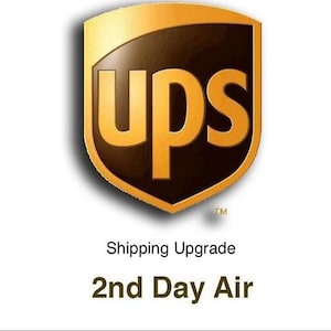 May include: The UPS logo, a shield-shaped emblem in gold and brown, with the letters "ups" in bold gold font. Below the logo, the text reads "2nd Day Air".