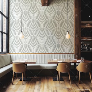 Pu&ograve; includere: Una sala da pranzo con una panca bianca e due tavoli in legno con sedie. Le pareti sono rivestite con una carta da parati a motivi geometrici bianchi e grigi. Due luci a sospensione pendono dal soffitto.