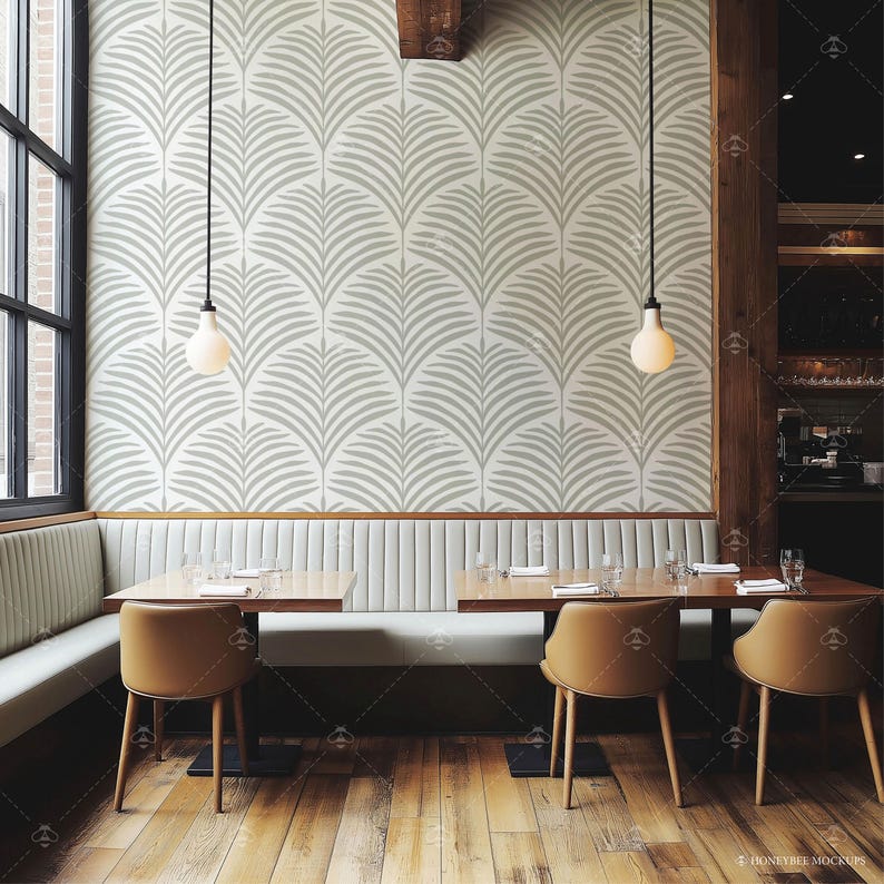Pu&ograve; includere: Una sala da pranzo con una panca bianca e due tavoli in legno con sedie. Le pareti sono rivestite con una carta da parati a motivi geometrici bianchi e grigi. Due luci a sospensione pendono dal soffitto.
