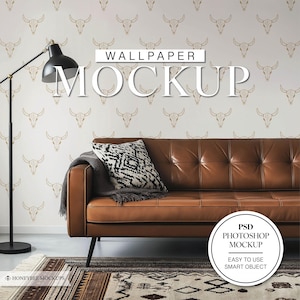 Könnte beinhalten: Ein Mockup eines Tapeten-Designs mit einem sich wiederholenden Muster aus goldenen Bullenschädeln auf weißem Hintergrund. Die Tapete wird an einer Wand hinter einem braunen Ledersofa mit einem schwarz-weiß gemusterten Kissen gezeigt. Der Text "WALLPAPER MOCKUP" wird in der Mitte des Bildes angezeigt. Der Text "PSD PHOTOSHOP MOCKUP EASY TO USE SMART OBJECT" wird in einem weißen Kreis unten rechts im Bild angezeigt.