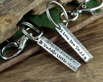 May include: Two silver keychains with engraved bars. One bar reads "I love you Daddy" and the other reads "Daddy's Little Man".