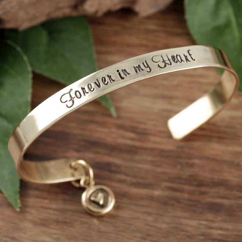 Puede incluir: Pulsera dorada con un dije y la inscripci&oacute;n "Forever in my Heart".