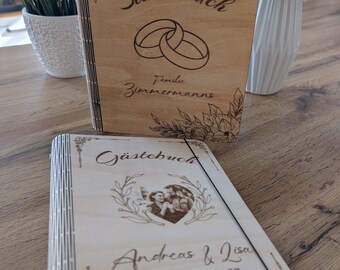 Puede incluir: Dos libros de visitas de madera con diseños grabados. El libro superior es un libro de registro familiar con el texto "Stammbuch" y "Familie Zimmermanns". El libro inferior es un libro de visitas con el texto "Gästebuch" y "Andreas & Lisa 09. Dezember 2022".
