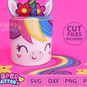 Puede incluir: Una caja de papel para manualidades con temática de unicornio con una melena y cola de arcoíris. La caja está decorada con flores y estrellas. La imagen incluye el texto "Paper Glitter" y "Cut Files Included".
