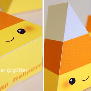 May include: A set of three yellow, orange, and white candy corn shaped boxes with a cute cartoon face. The boxes have the text "paper * glitter" and "Happy Halloween" on them.