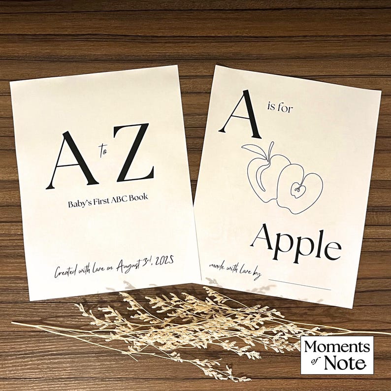 May include: Two cream-colored baby ABC books with black text. One book reads "A to Z Baby's First ABC Book" and "Created with love on August 31, 2025." The other book reads "A is for Apple" with an apple illustration.