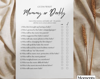 Peut inclure: Une feuille de jeu blanche pour une baby shower, intitulée "Mommy or Daddy" en écriture cursive. La feuille propose une liste de questions avec des cases à cocher pour les invités. Le logo "Moments of Note" est visible en bas à droite.