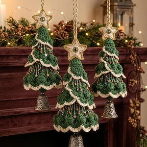 Puede incluir: Tres adornos colgantes para árbol de Navidad hechos de ganchillo verde oscuro con bordes festoneados de color crema. Cada árbol está rematado con una estrella crema, decorado con cuentas multicolores y pequeñas estrellas, y tiene una campana de metal plateado en la base.