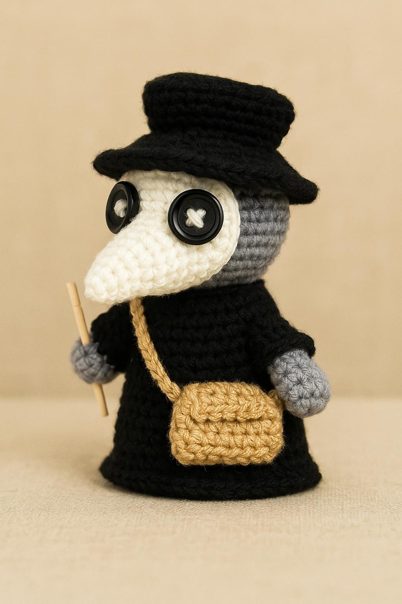 Peut inclure: Poup&eacute;e au crochet faite &agrave; la main repr&eacute;sentant un m&eacute;decin de la peste, avec un chapeau et un manteau noirs, un masque blanc en forme de bec et une petite sacoche beige. La poup&eacute;e a de grands yeux en boutons et tient un b&acirc;ton en bois.