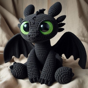 Puede incluir: Un dragón negro de ganchillo hecho a mano con grandes y expresivos ojos verdes. El dragón tiene alas, orejas y pies detallados, y está sobre una superficie de color neutro. Este peluche es un artículo único.