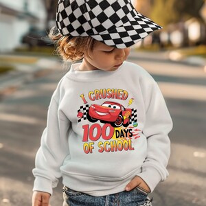 a young child wearing a white sweatshirt and a checkered hat