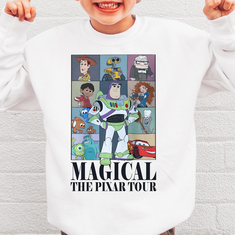 A white t-shirt with a collage of characters from the animated film "Pixar's Magical The P Pixar Tour" printed on it.