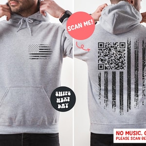 May include: A gray hoodie with a distressed American flag design on the front and back. The back features a QR code within the flag's stripes. The hoodie has a front pocket and a drawstring hood. Text on the image says "SCAN ME!" and "NO MUSIC, GIF ONLY! PLEASE SCAN BEFORE BUYING."
